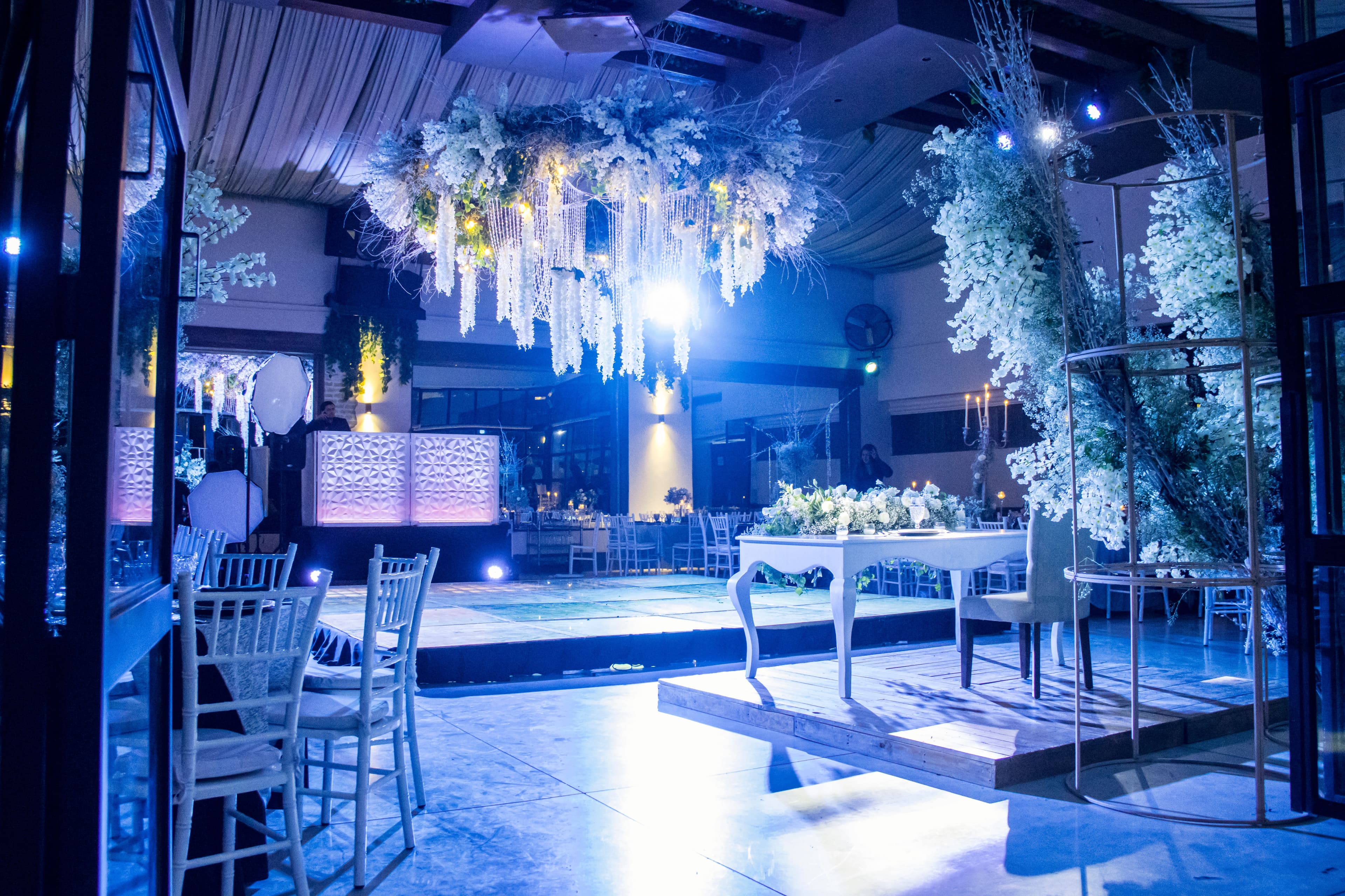 Sala ricevimenti con installazione floreale e cabina DJ
